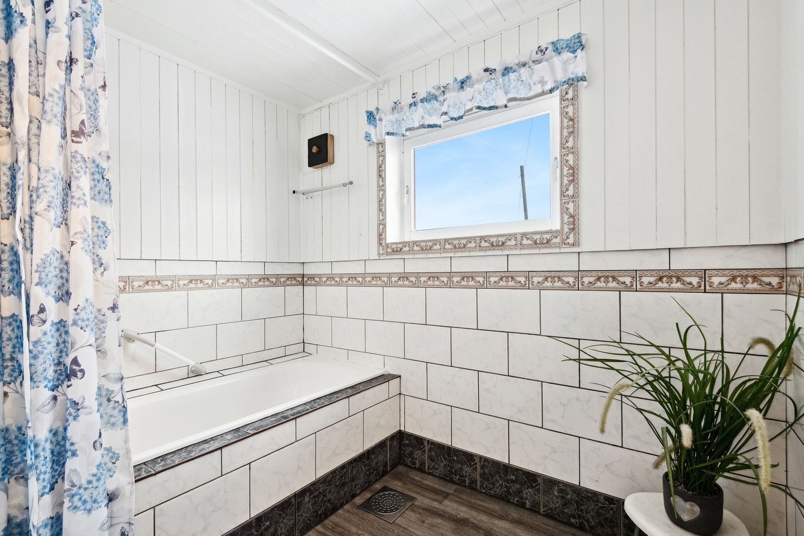 Badet inneholder åpen dusj i innebygd badekar og servant i innredning. Galleribilde