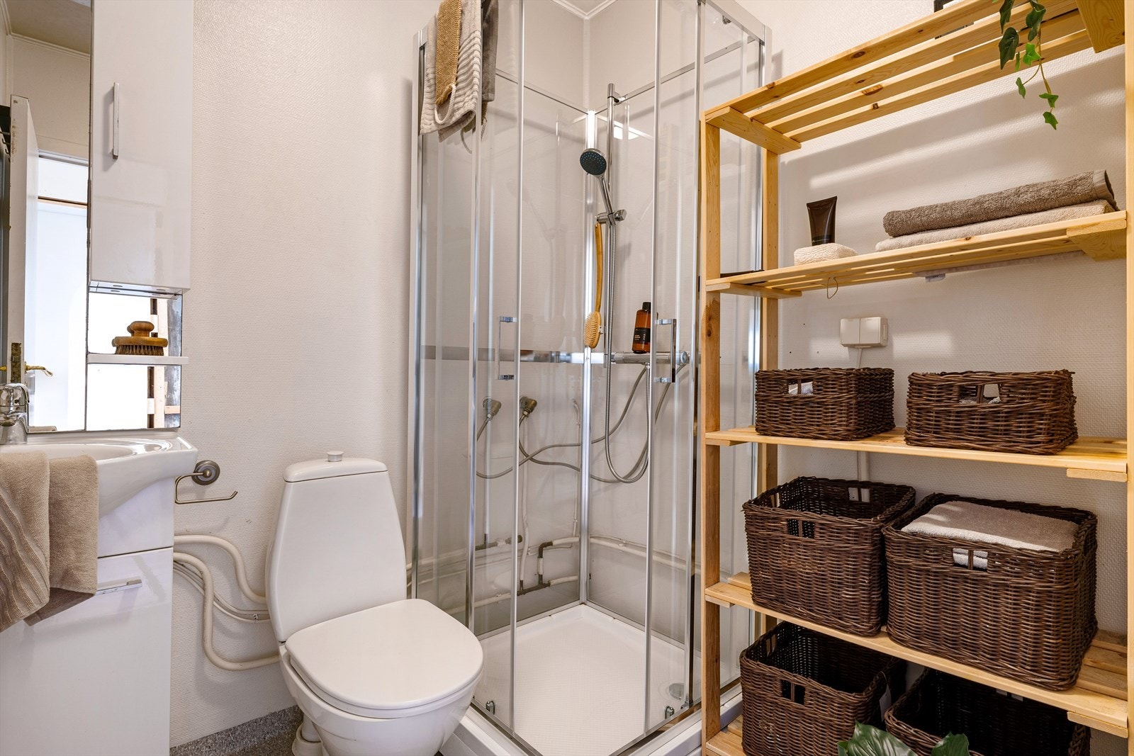 Det inneholder dusjkabinett, servant i møblement, speil og toalett. Galleribilde