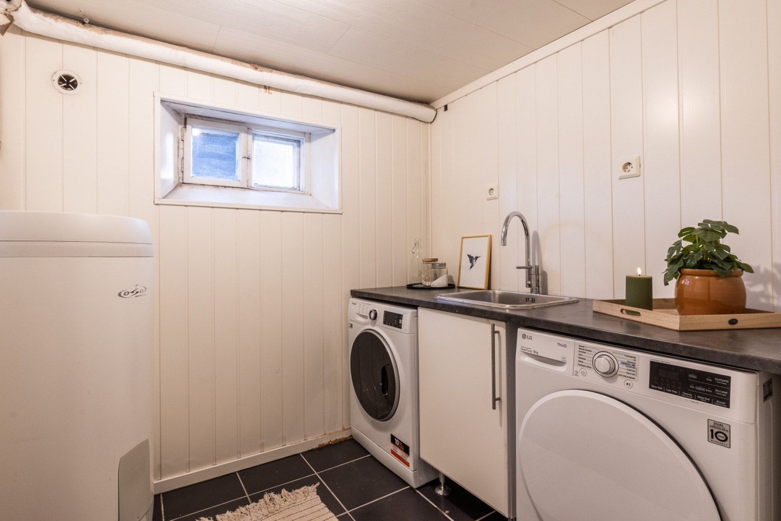 Praktisk vaskerom med opplegg for både vaskemaskin og tørketrommel Galleribilde