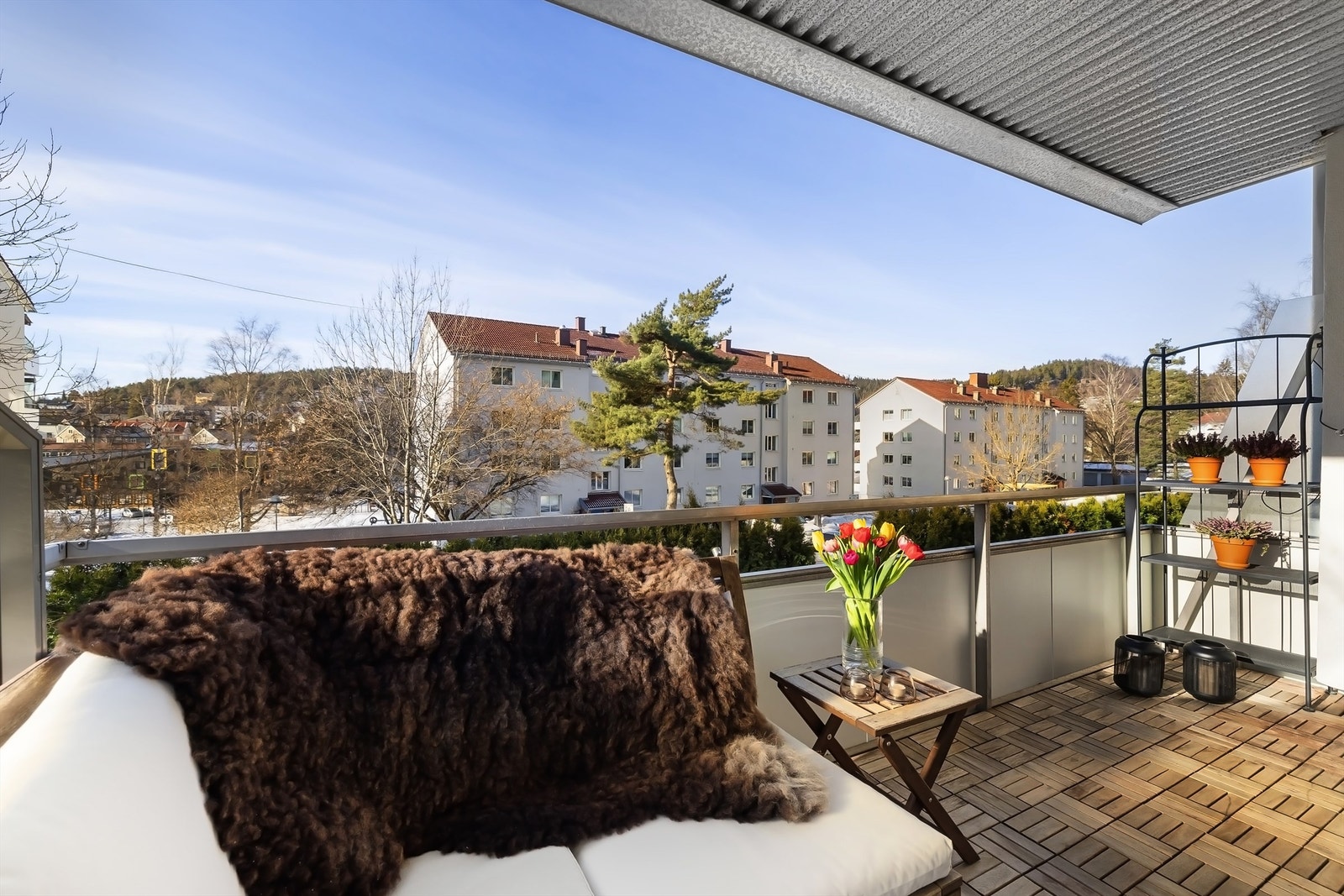 Balkongen er belagt med tre-heller og har rekkverk av glass/metallkonstruksjoner. Galleribilde