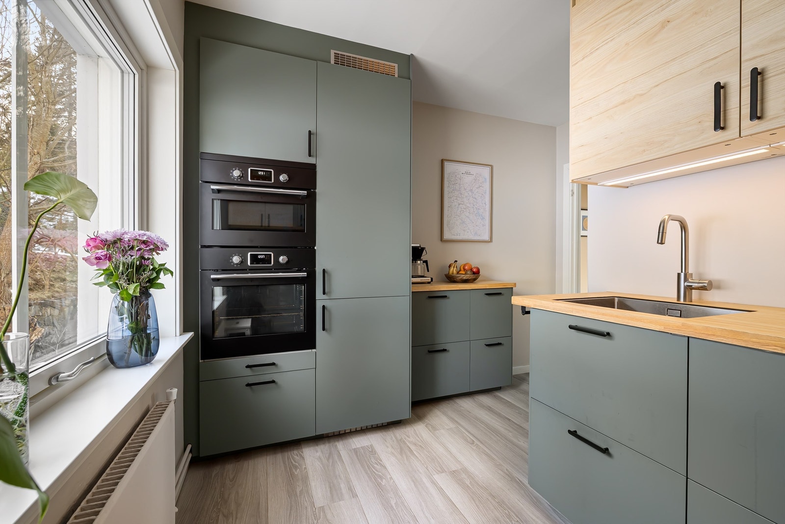 Flott kjøkken fra 2022 - Glatte fronter, benkeplate av heltre, overbelysning, stikkontakter og integrerte hvitevarer. Galleribilde