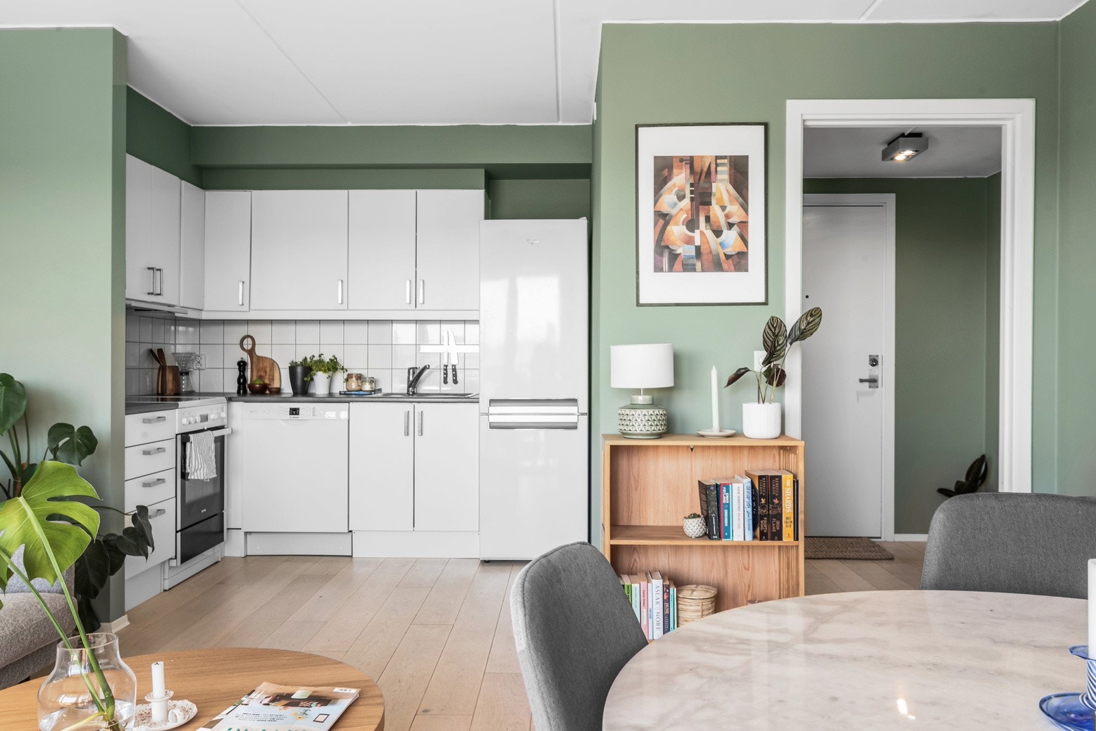 Tidløs kjøkkeninnredning fra 2008, med hvite slette fronter. Benkeplate i laminert spon med stålkom med ett-greps blandebatteri. Galleribilde