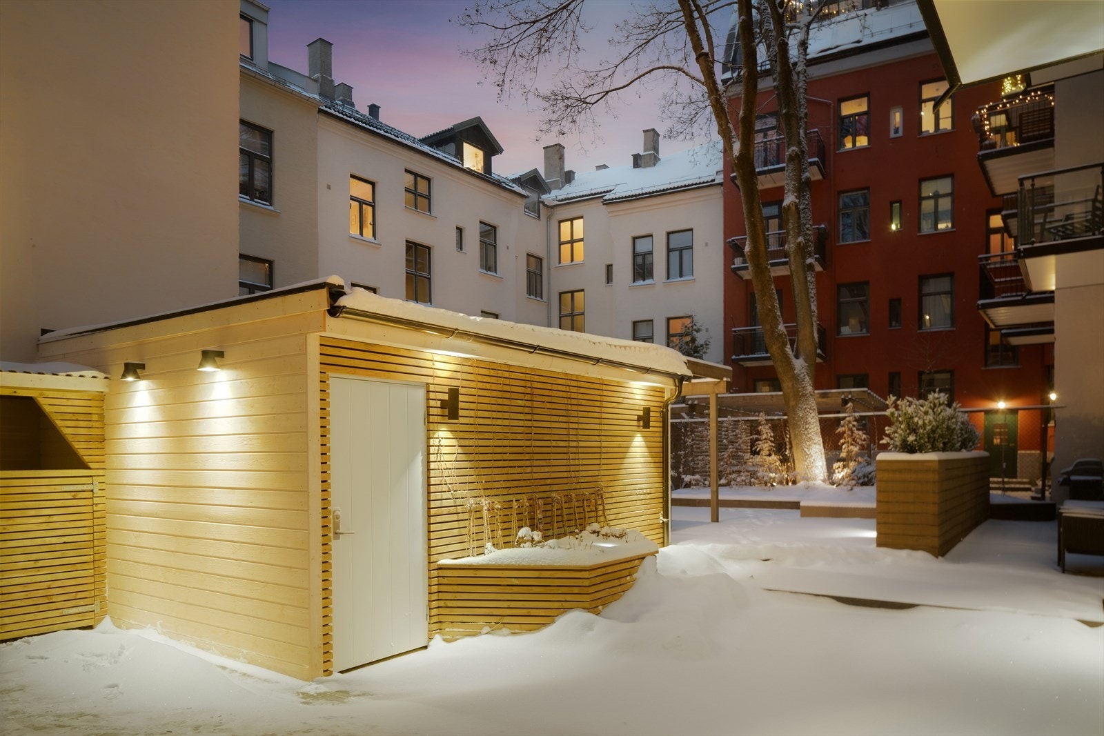Hyggelig fellesarealer i bakgård med terrasse, beplantning, sykkelparkering og avfallshåndtering. Galleribilde