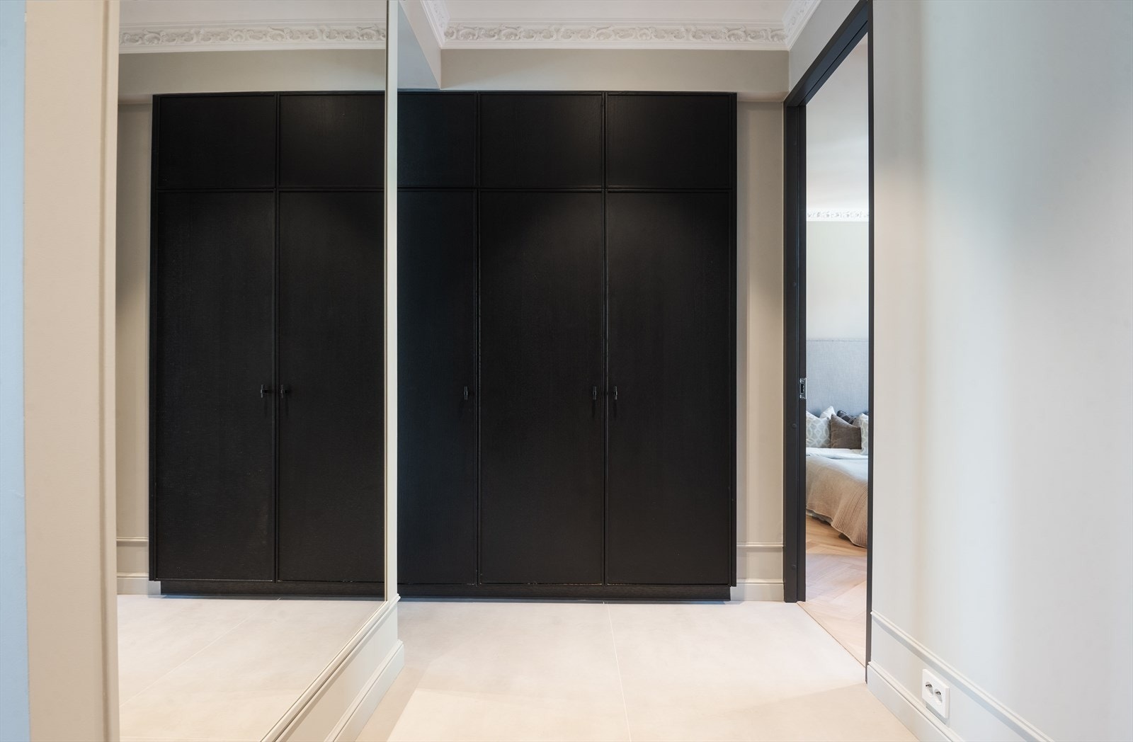 Romslig entré med garderobeskap fra Bekkestua Kjøkkenstudio, stort speil og 120 x 120 cm fliser fra Bella Studios. Galleribilde