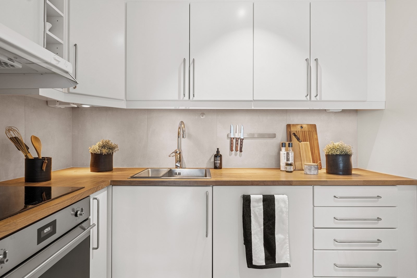 Innredningen inkluderer integrert kjøl-/fryseskap, oppvaskmaskin, komfyr og platetopp. Benkeplate i eik. Galleribilde