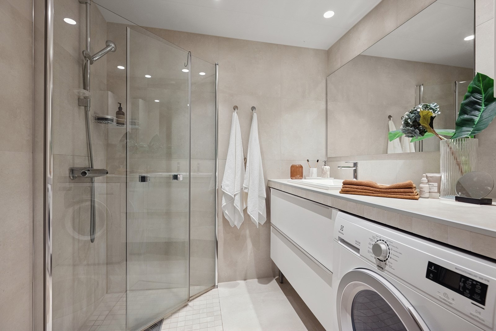 Baderommet er oppgradert med lekre grå fliser og nyere innredning. Det er gulvvarme og downlights samt dusjhjørne, vegghengt toalett, servant, benkeplate med servant, skuffeseksjon under og opplegg for vaskemaskin. Galleribilde