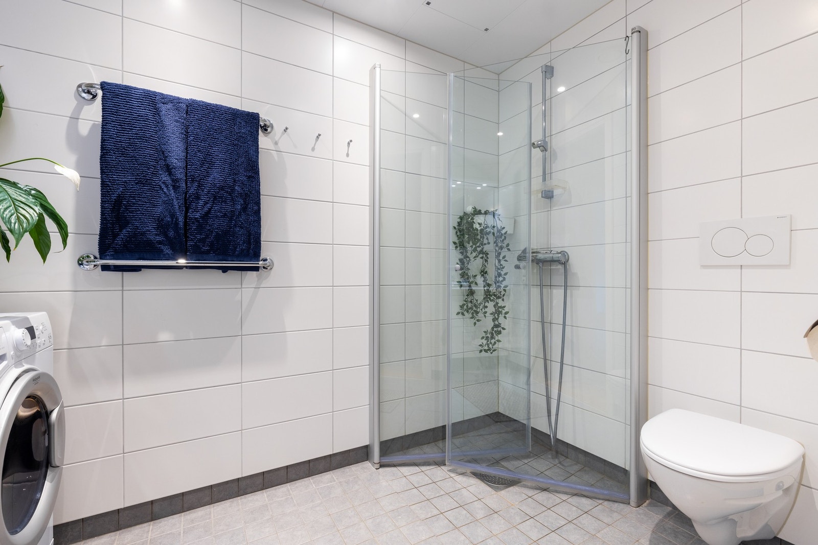 Videre er det vegghengt toalett og dusjhjørne med svingbare dører i glass som frigjør plass på gulvet. Galleribilde