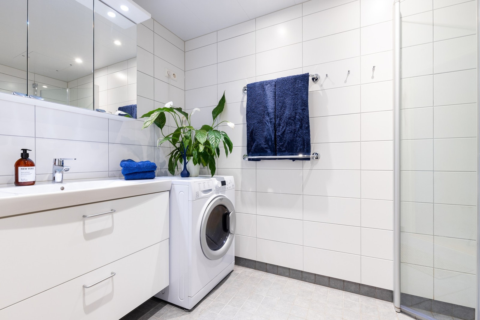 Lyst baderom med varme i gulv og opplegg for vaskemaskin. Downlights i himling. Galleribilde