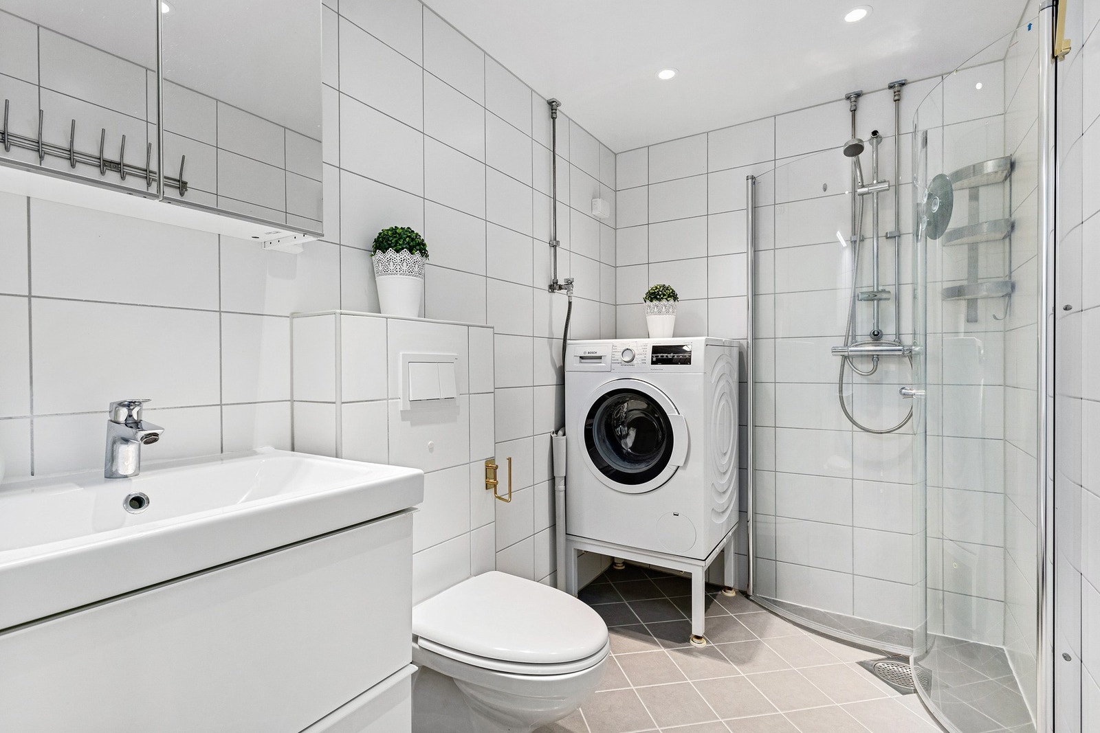 Lyst, flislagt baderom med gulvvarme og downlightsbelysning i taket. Badet ble pusset opp i 2017 i regi av borettslaget Galleribilde