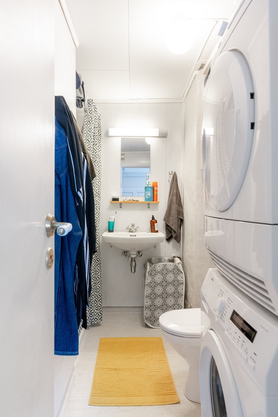 Lite, lyst bad av eldre standard i 1. etasje, utstyrt med gulvmontert toalett, vegghengt servant og dusjnisje med forheng, samt opplegg for vaskemaskin. Galleribilde