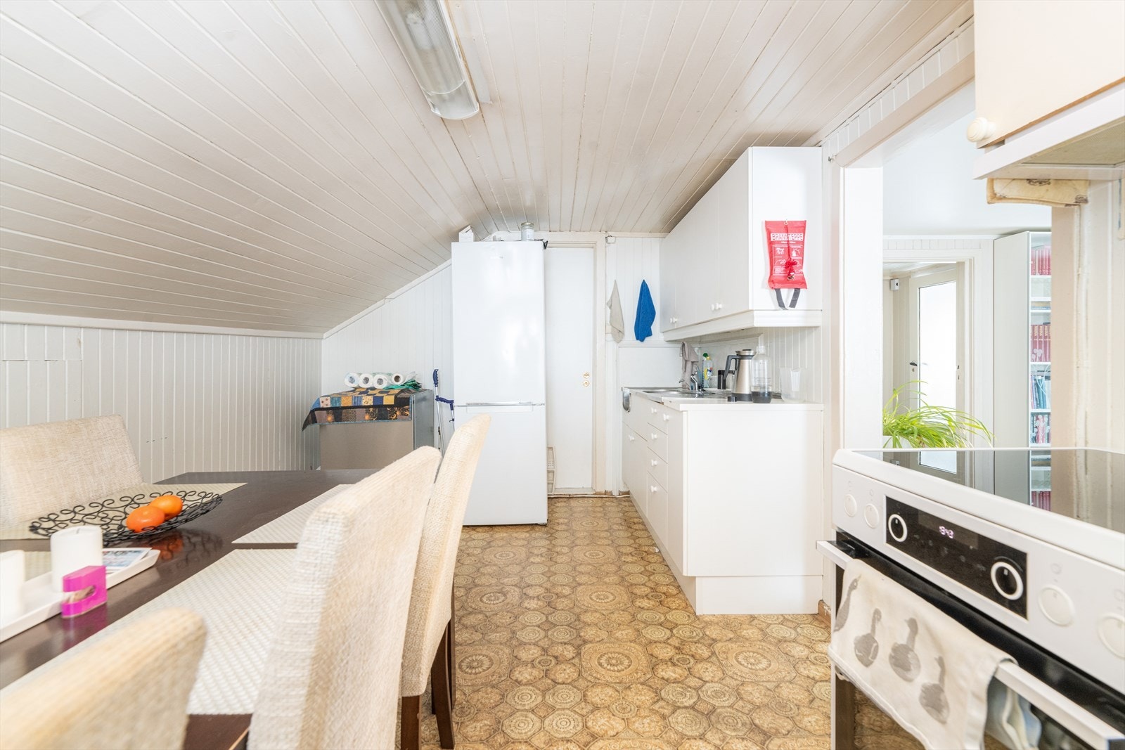 Laminat benkeplate og heldekkende benkebeslag i rustfritt stål. Det er avsatt plass til frittstående hvitevarer. Galleribilde