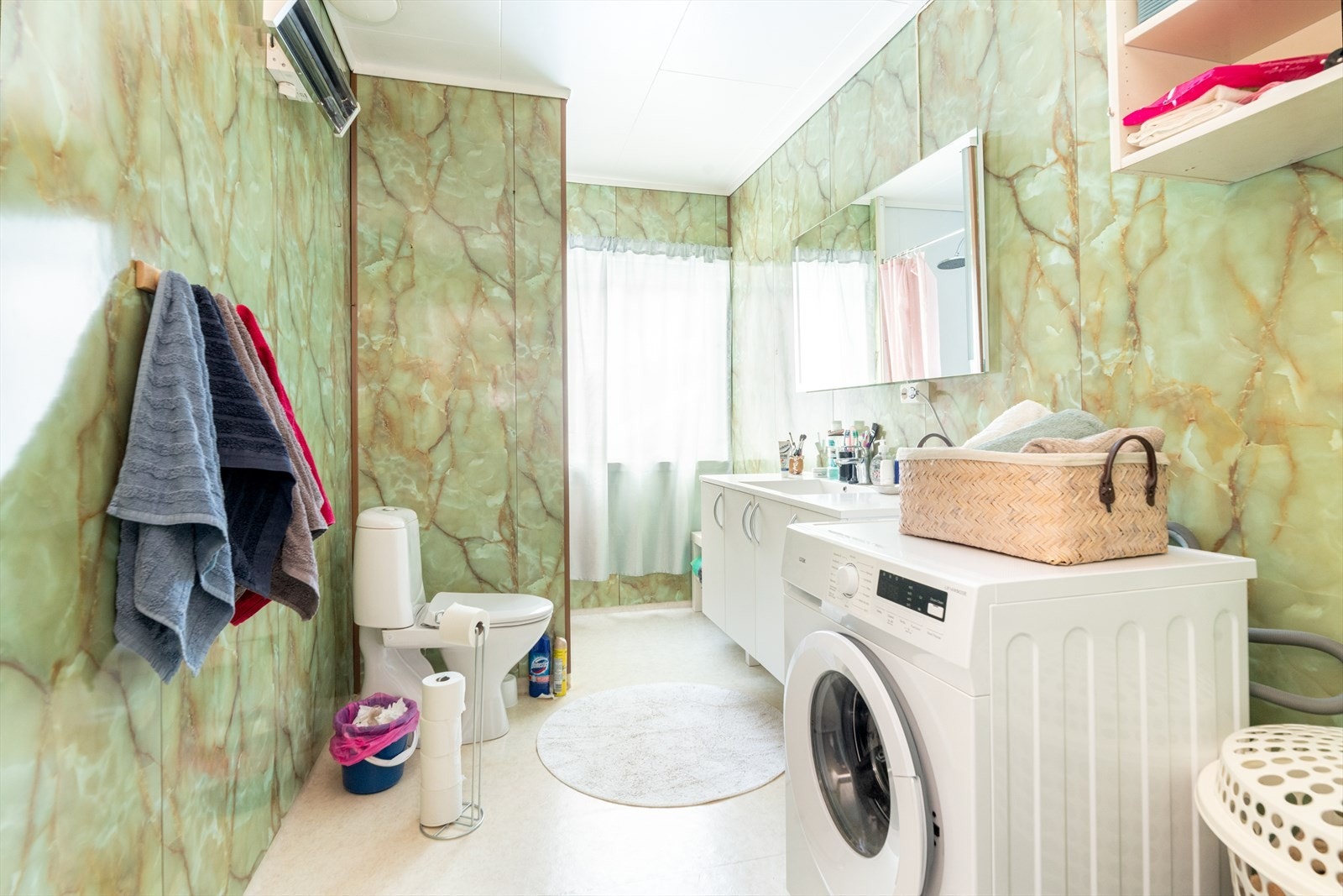 Romslig bad av eldre standard, antatt fra 1980-tallet. Nyere servantinnredning med heldekkende servantplate, samt speil med integrert belysning. Galleribilde