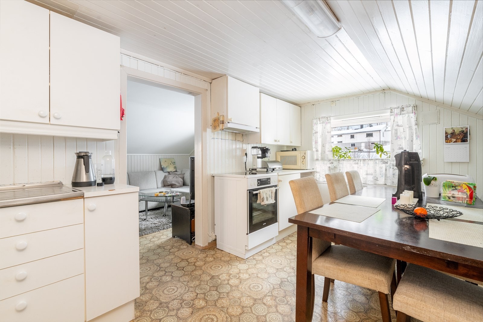 Lyst og romslig kjøkken av eldre standard, med fin plass til spisegruppe. Innredningen har godt med skapplass og fronter i glatt utførelse. Galleribilde