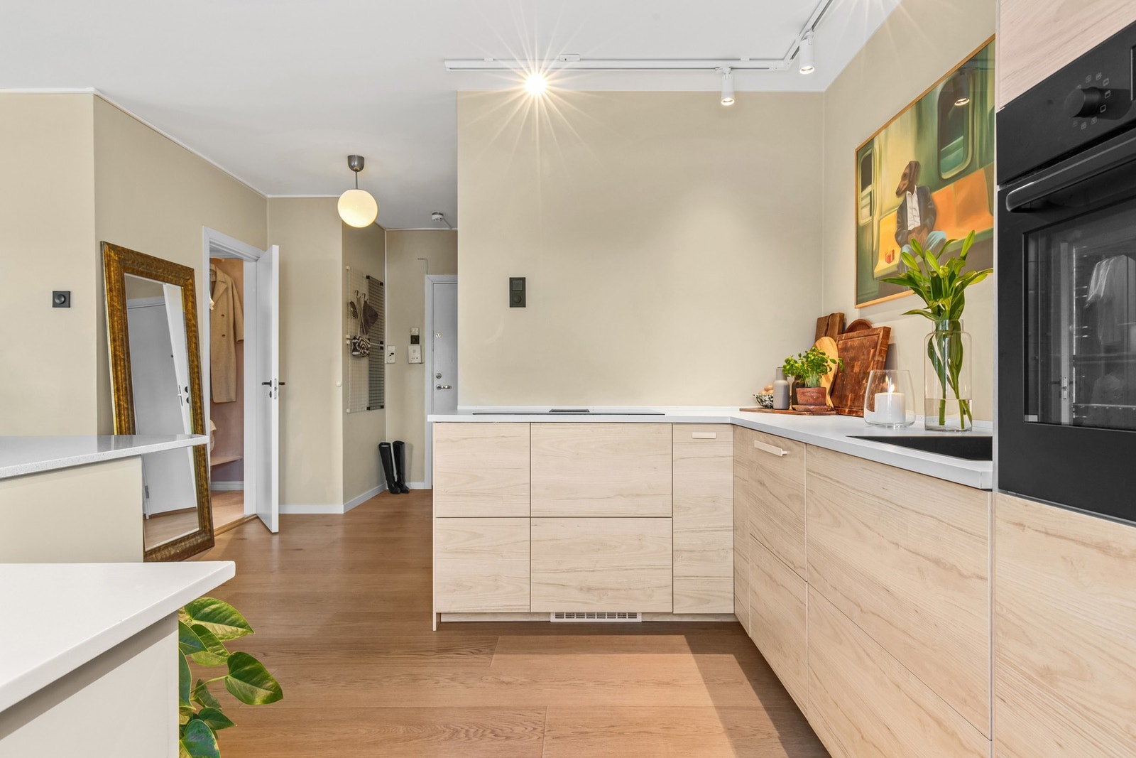 Kjøkkenet er designet for effektiv bruk av plassen, med smarte skap- og hylleløsninger som hjelper deg å holde orden. Det funksjonelle lyset gir god belysning over arbeidsflater når du lager mat. Galleribilde