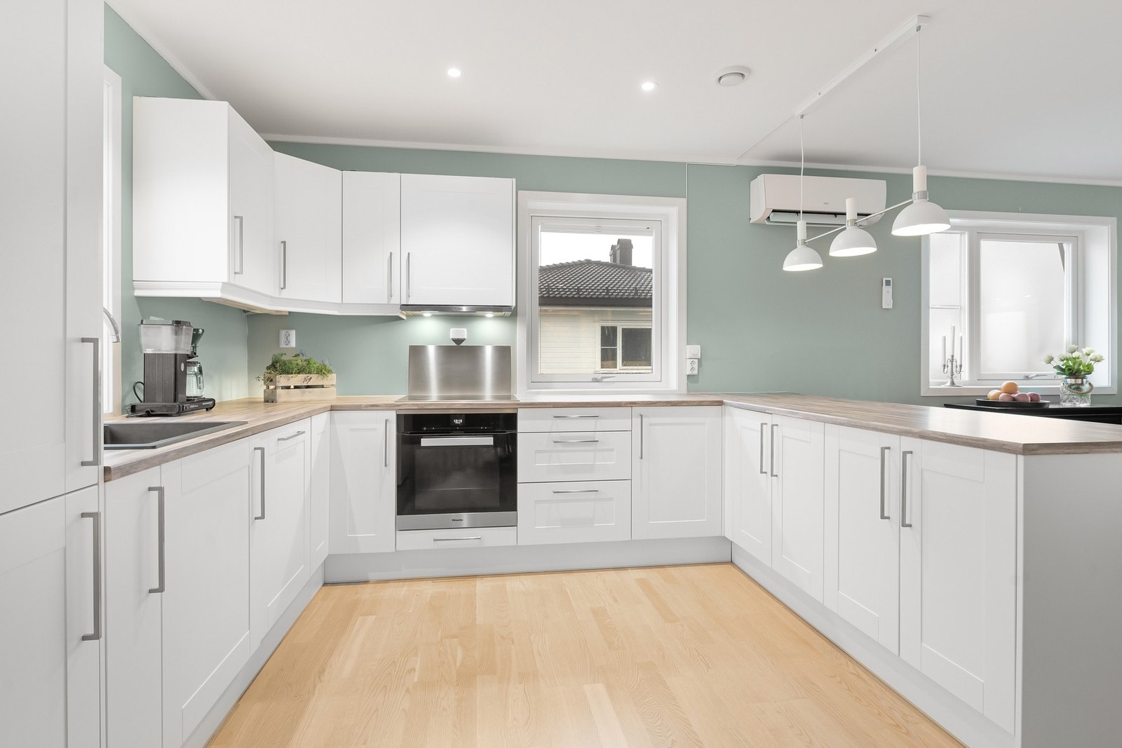 De hvite frontene gjør kjøkkenet lyst og trivelig. Legg også merke til varmepumpe. Galleribilde