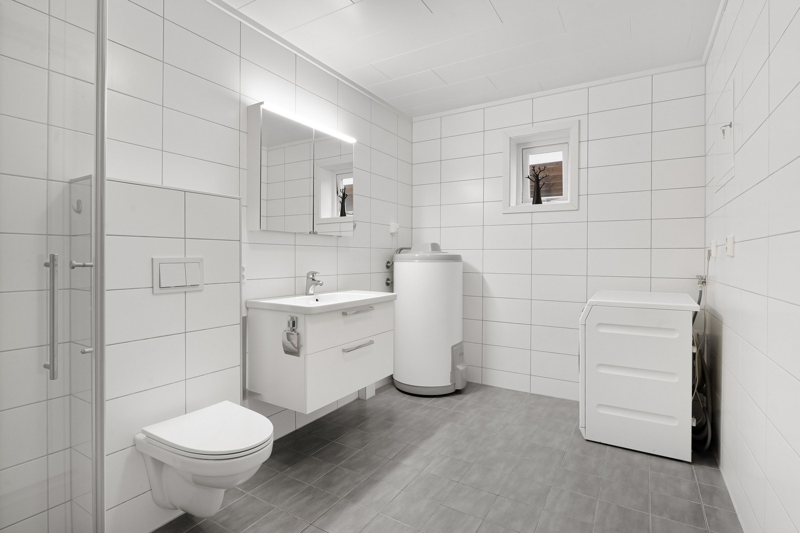 Bad innredet med servant, dusjkabinet og vegghengt WC. Galleribilde