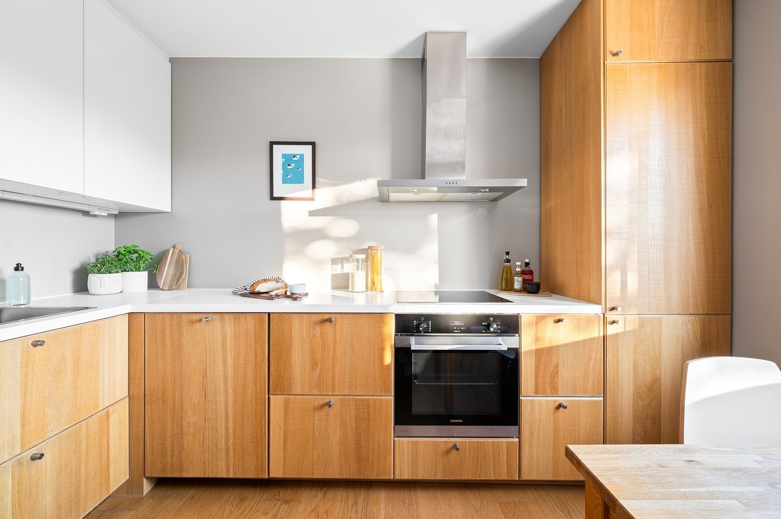 Flott separat kjøkken fra 2014 med glatte fronter, benkeplate i laminat og malt vegg over kjøkkenbenk. Galleribilde