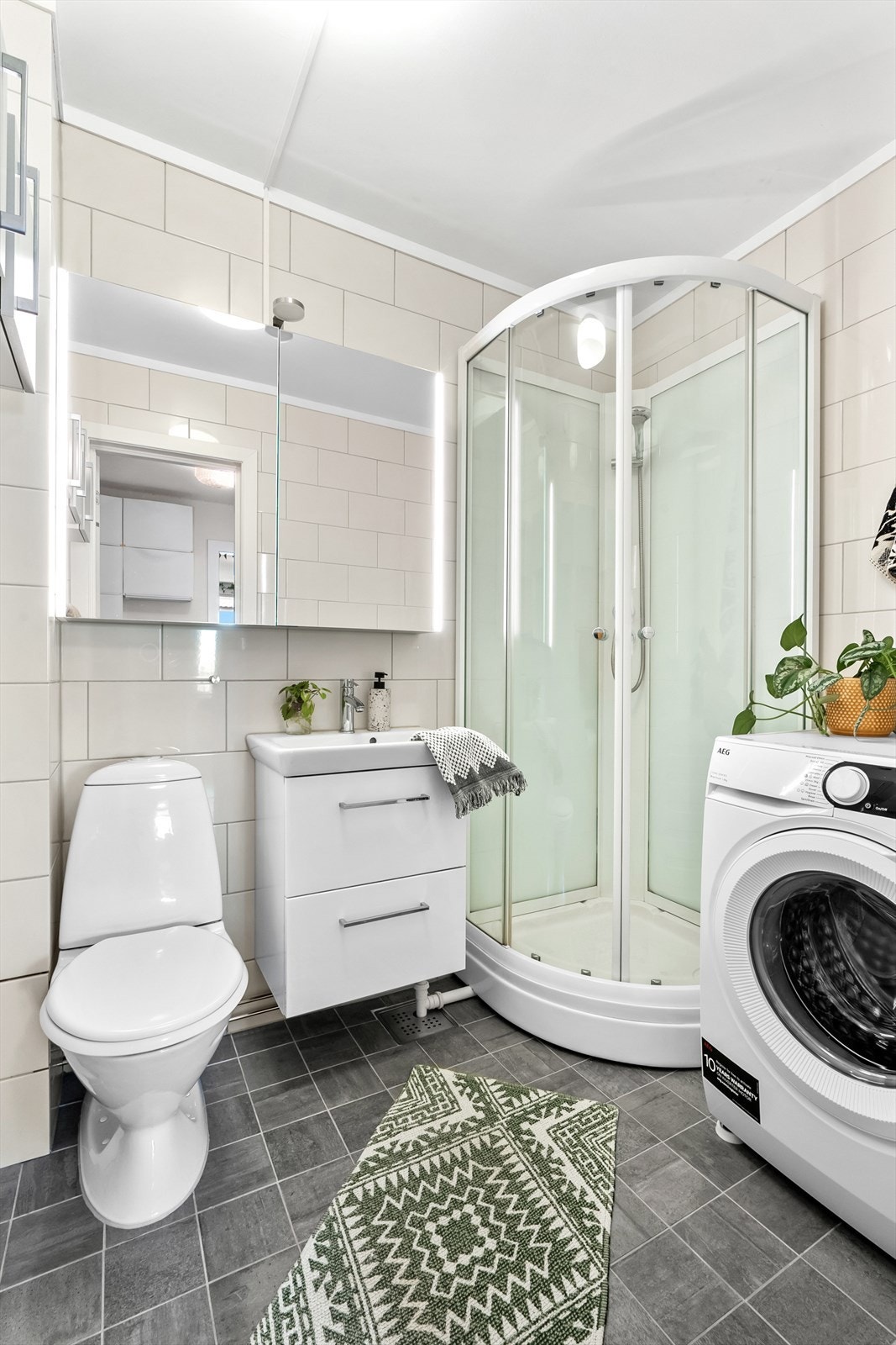 Delikat flislagt baderom med behagelig gulvvarme. Opplegg for vaskemaskin og plass til tørketrommel. Galleribilde