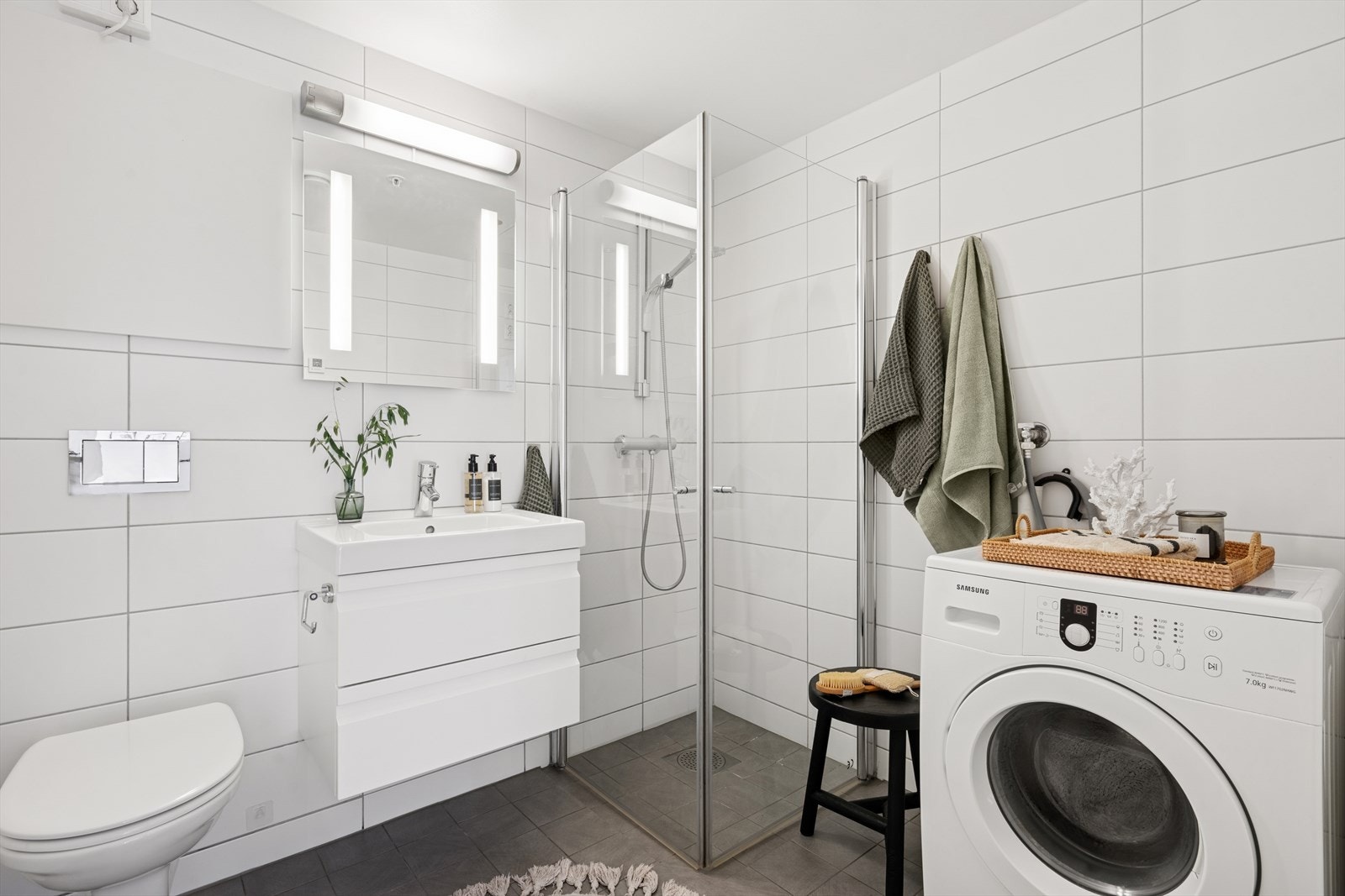 Det flislagte baderommet har varme i gulvet, innfelte downlights i himlingen og opplegg for vaskemaskin. Galleribilde