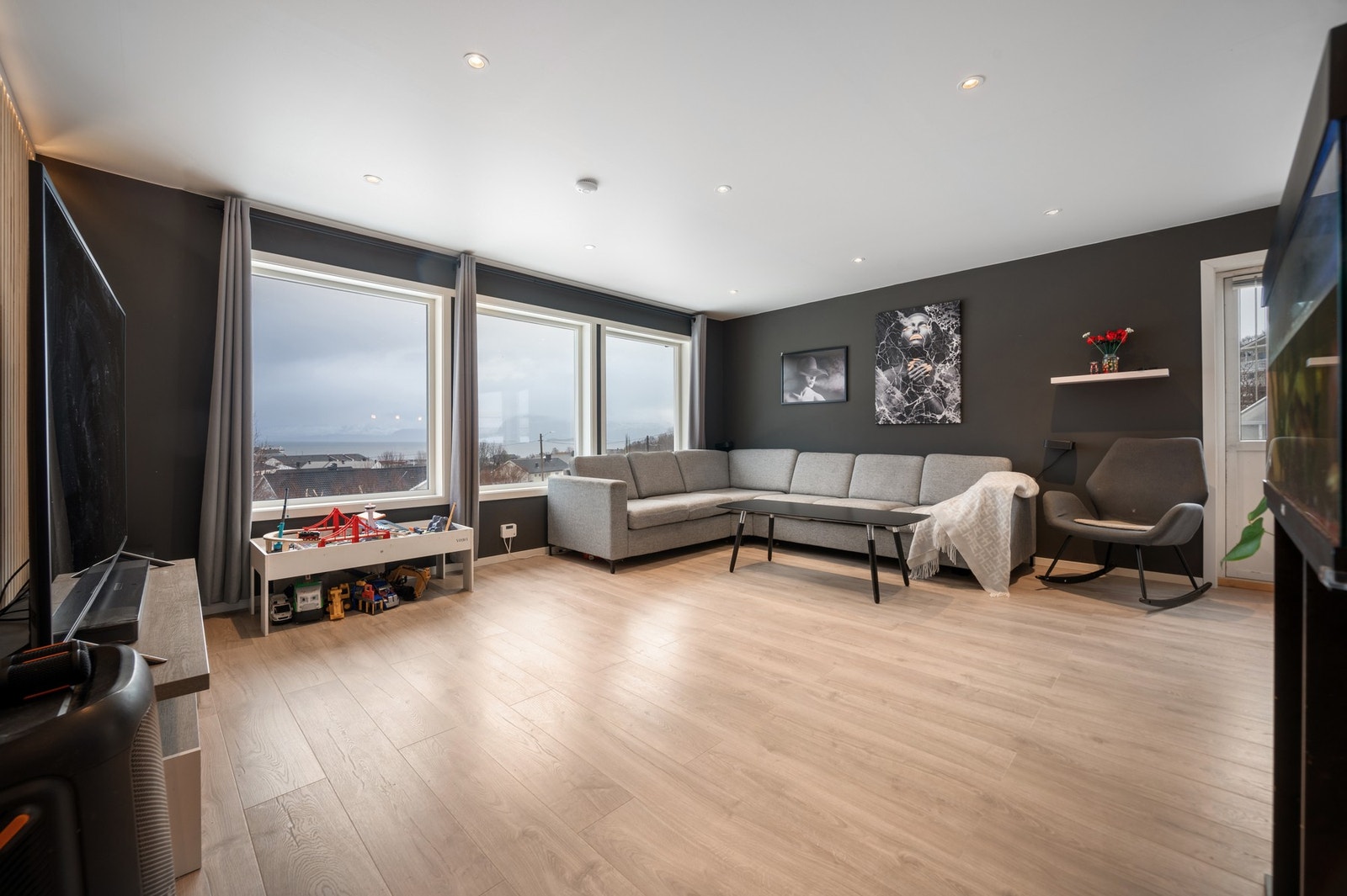 Romslig og åpen stue med store vinduer som gir godt innslipp av dagslys Galleribilde