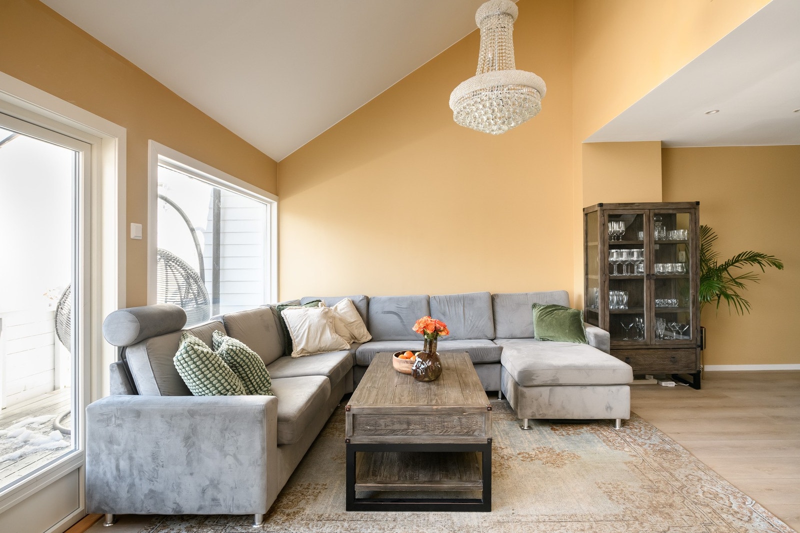 Det er utgang til en balkong med kveldssol og idyllisk utsyn. Stuen ligger i åpen løsning med kjøkkenet og har pene overflater og trendy fargevalg. Galleribilde