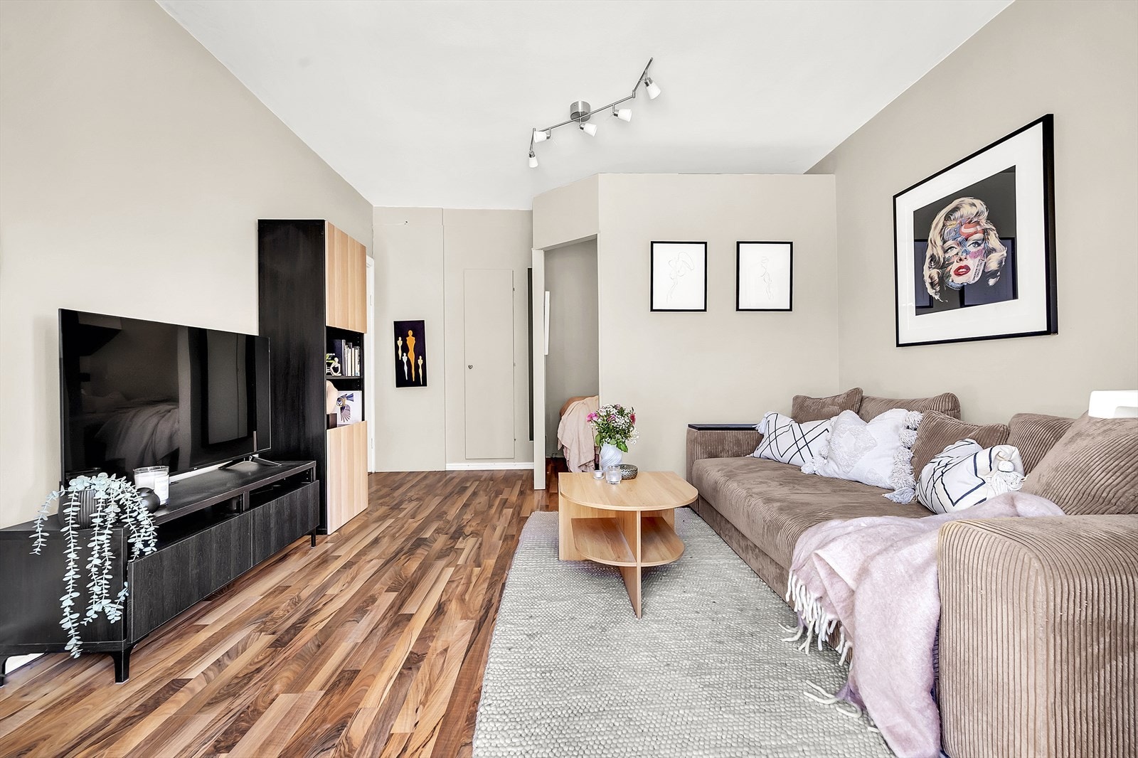 Den åpne planløsningen gir fleksible møbleringsmuligheter, med god plass til både sofagruppe, TV-møbler og andre ønskede innredningsløsninger, noe som gir rommet et luftig og tilpassbart preg. Galleribilde