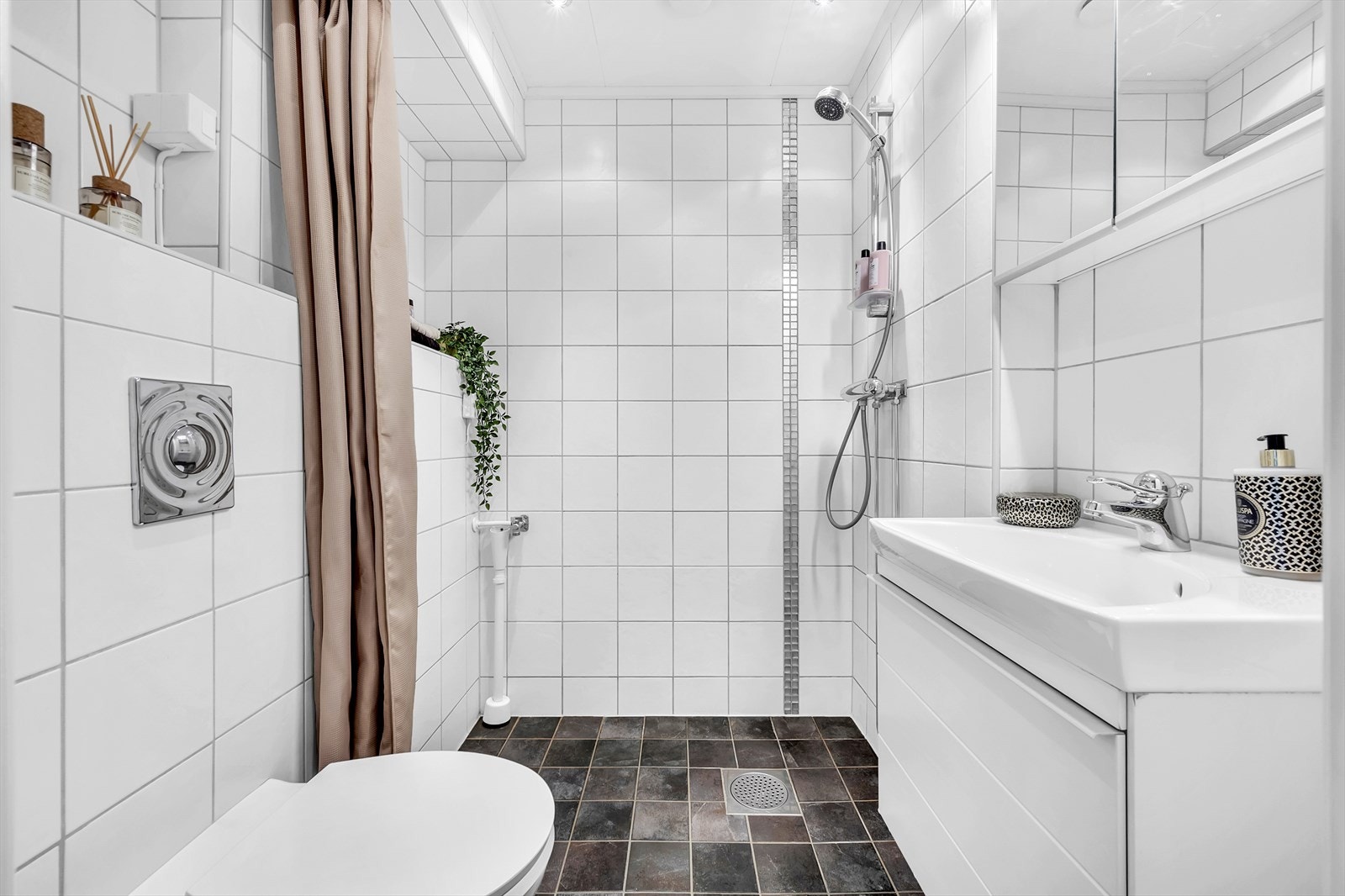 Pent flislagt baderom med elektrisk gulvvarme og opplegg for vaskemaskin. Galleribilde