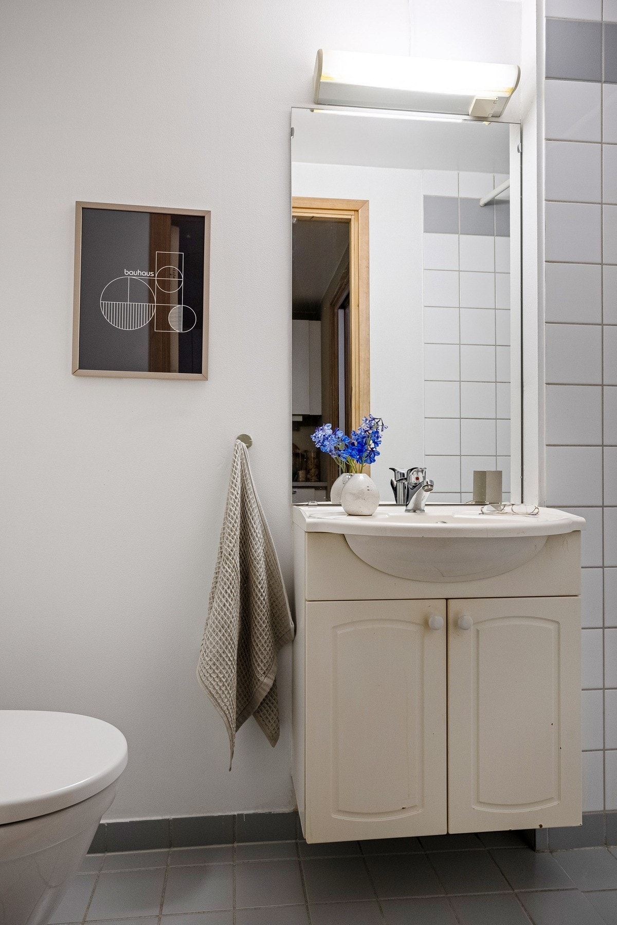 Badet inneholder speil, servant med underskap, dusjhjørne og toalett. Galleribilde