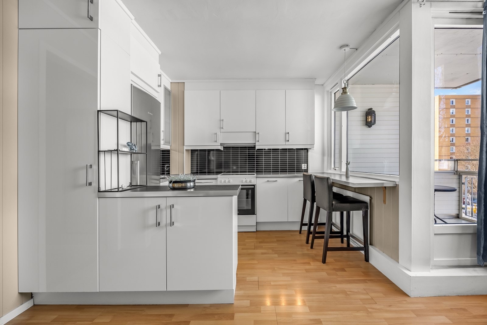 Lyst kjøkken med glatte fronter, og mye skap- og benkeplass. Galleribilde