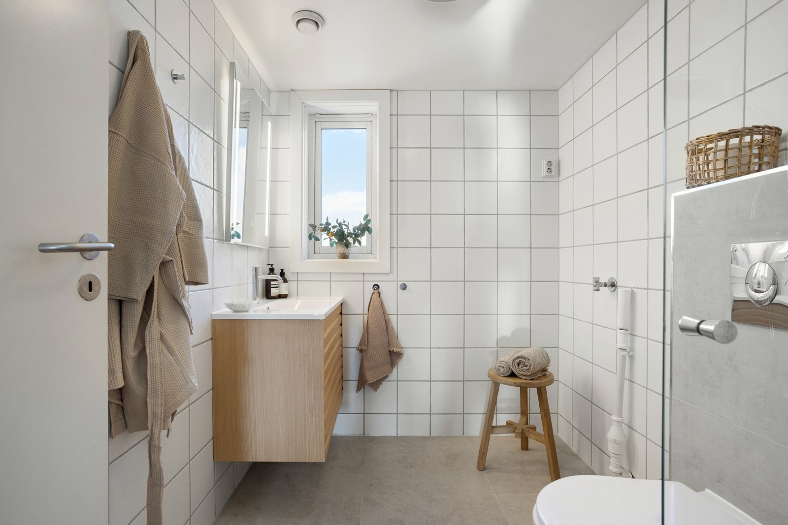 Det andre badet er også oppgradert i 2025 med flis-på-flis på gulv og ny innredning. Her er det opplegg for vaskemaskin. Galleribilde