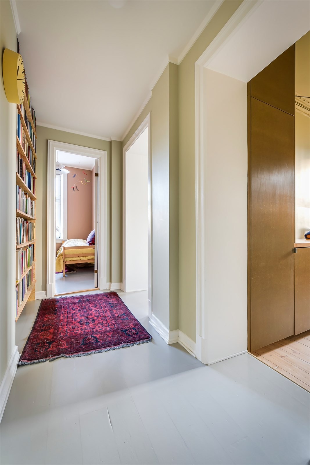 Innbydende entré med god plass til å henge fra seg ytterklær og sko, samt en plassbygget bokhylle i nisje Galleribilde