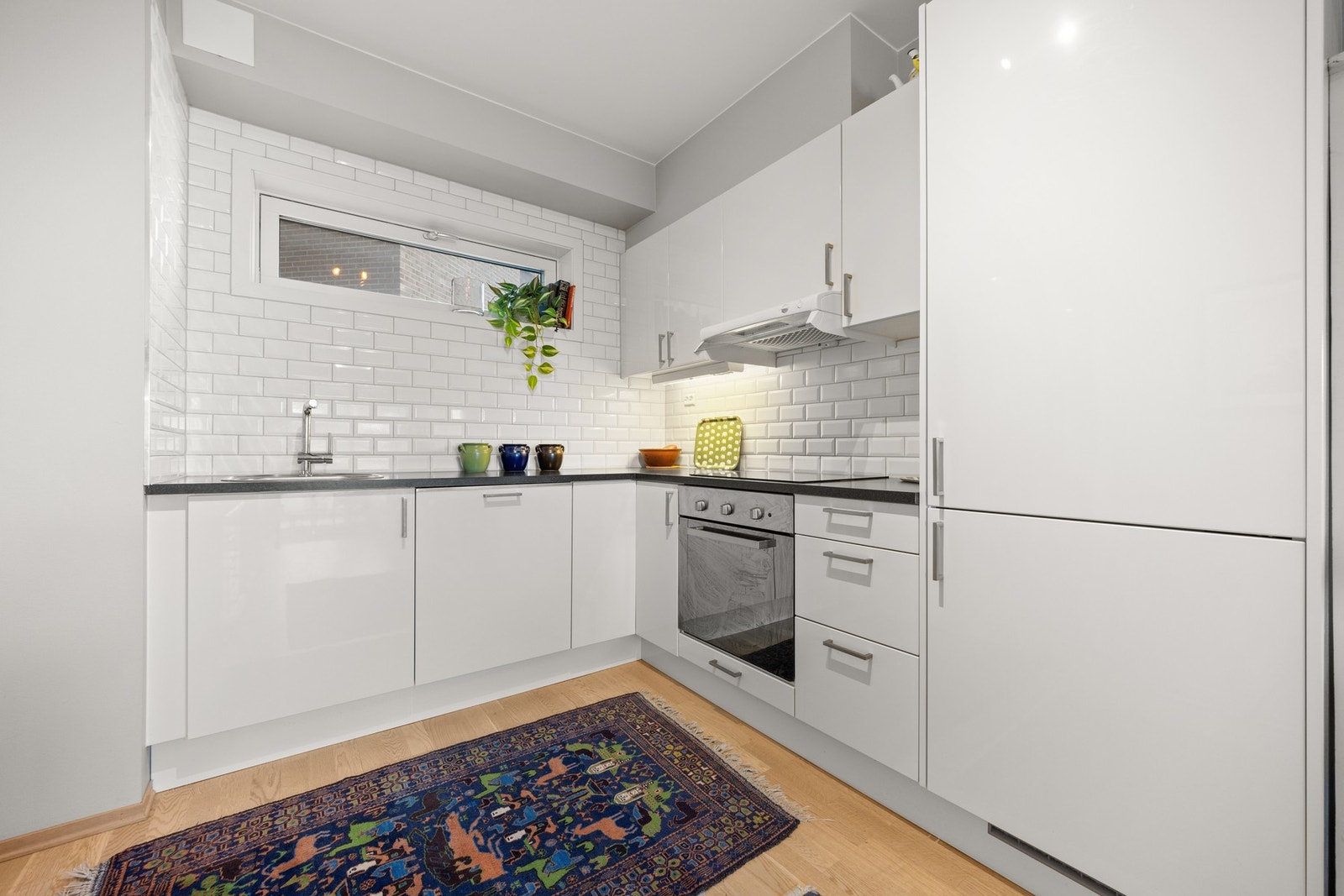 Kjøkkeninnredning med slette fronter og laminat benkeplate Galleribilde