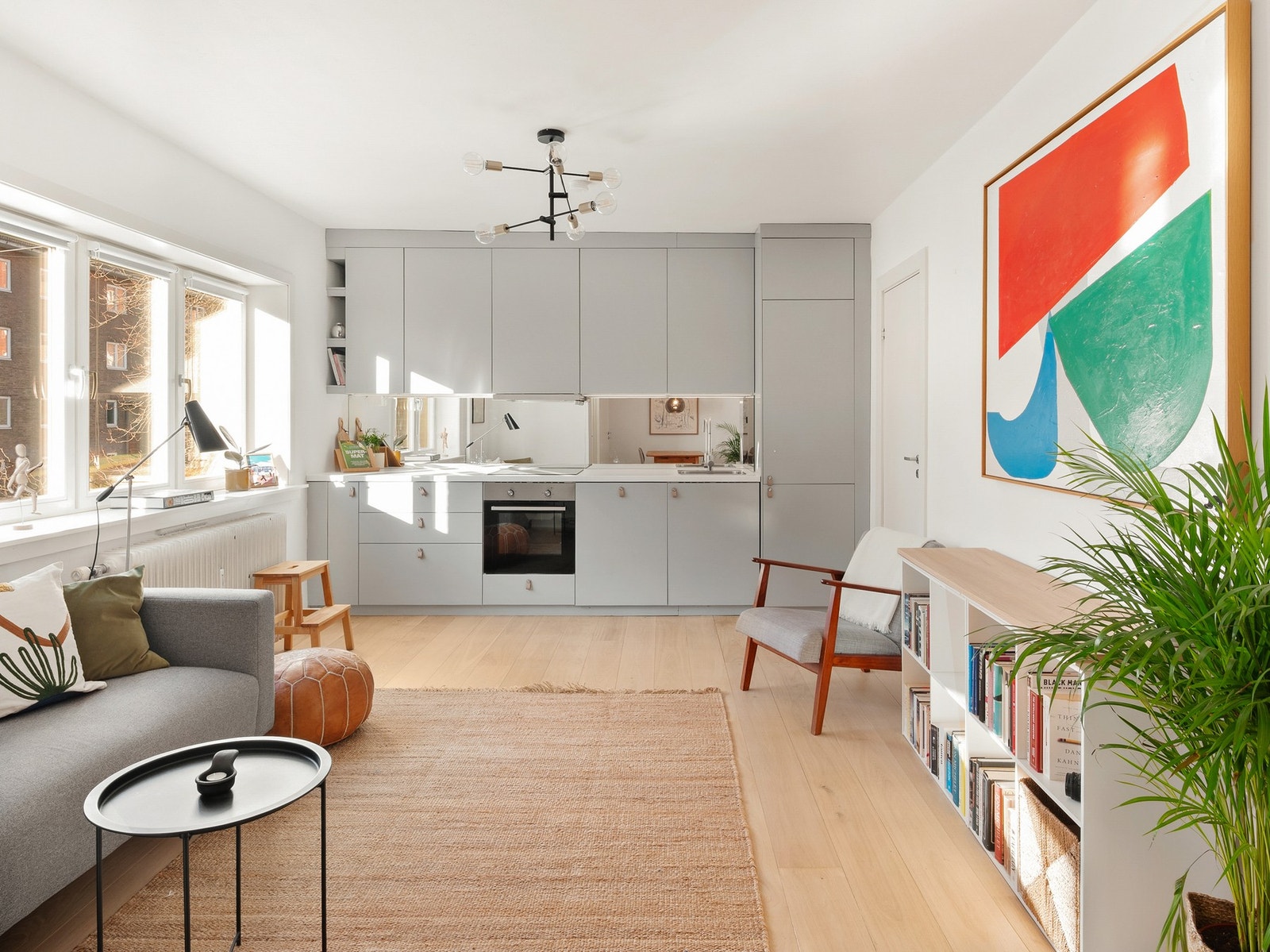 Kjøkkenet har en stilren innredning med glatte fronter, en glassplate over benkeplaten og moderne, integrerte hvitevarer. Galleribilde