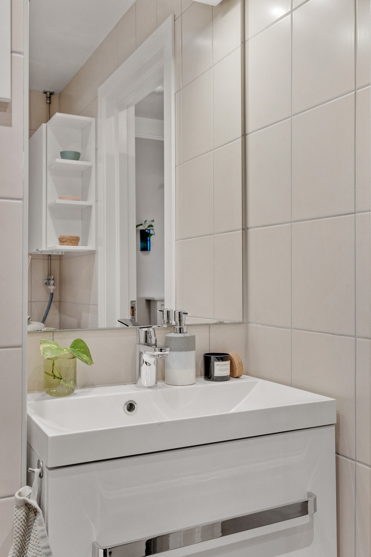 Badet er utstyrt med en enkel vegghengt servant, vegghengt toalett og dusjdører i glass. Galleribilde