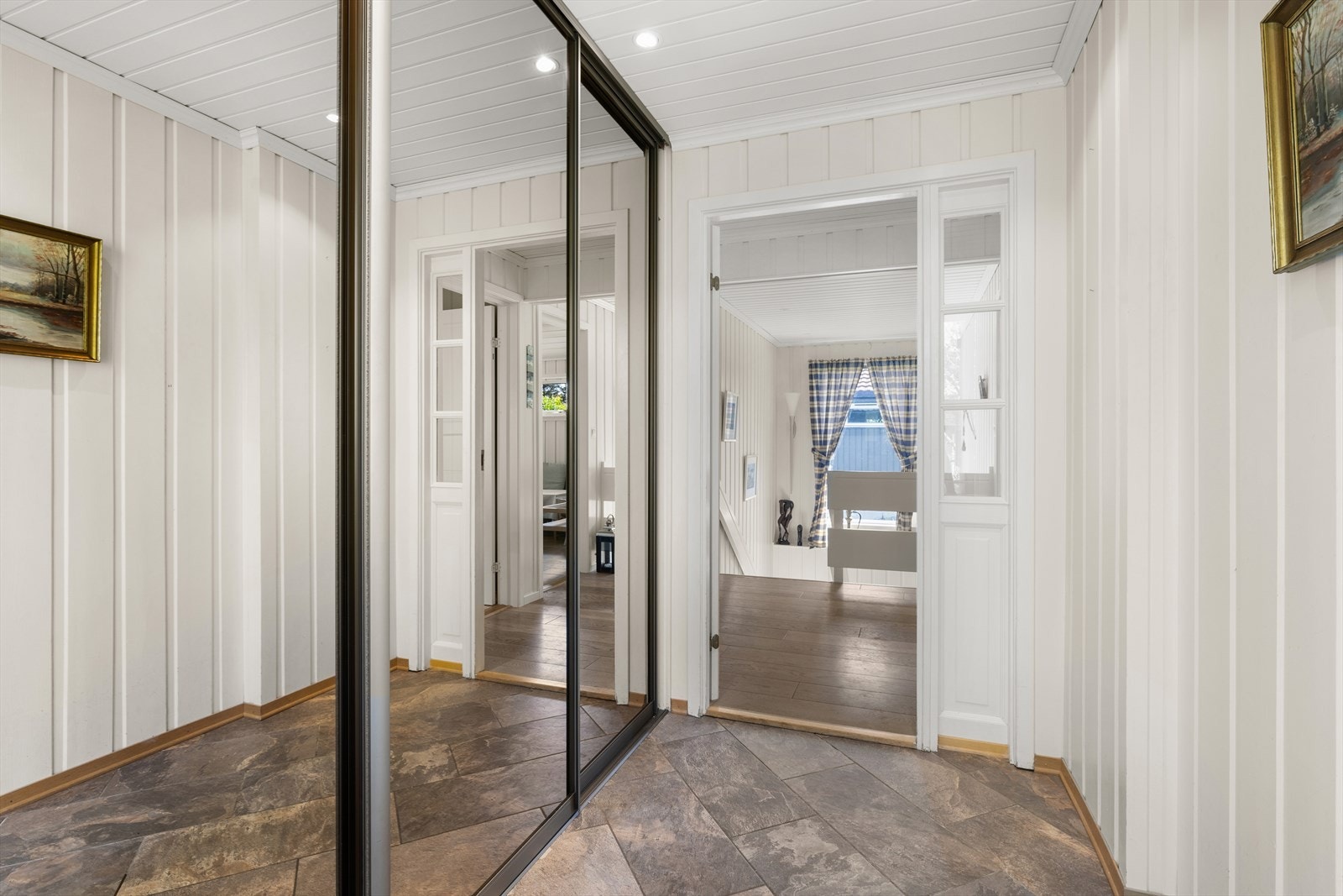 Entre med flislagt gulv og romslig skyvedørsgarderobe Galleribilde