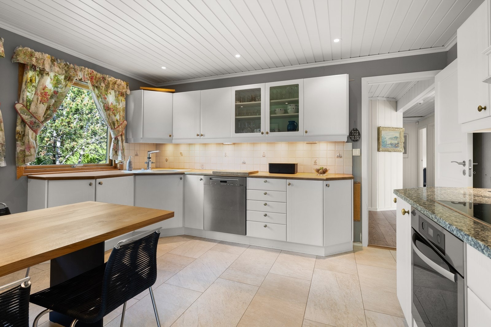 Kjøkken med profilerte fronter, heltre eik benkeplate og steinplate på kokesone. Nedfelt kum, kran med elektronisk innstilling. Galleribilde