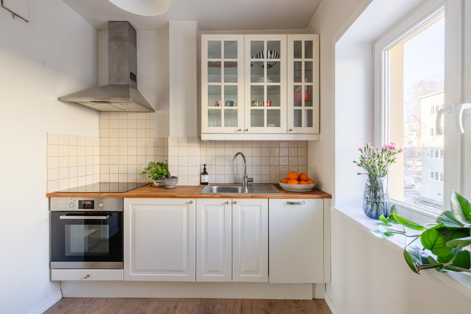 Kjøkkenet har hvit innredning med heltre benkeplate. Galleribilde