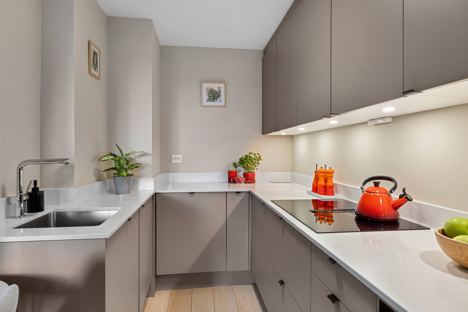 Kjøkkenet er utstyrt med en moderne benkeplate i granitt med marmormønster og nedfelt oppvaskkum, samt benkebelysning som gir god arbeidsbelysning. Galleribilde