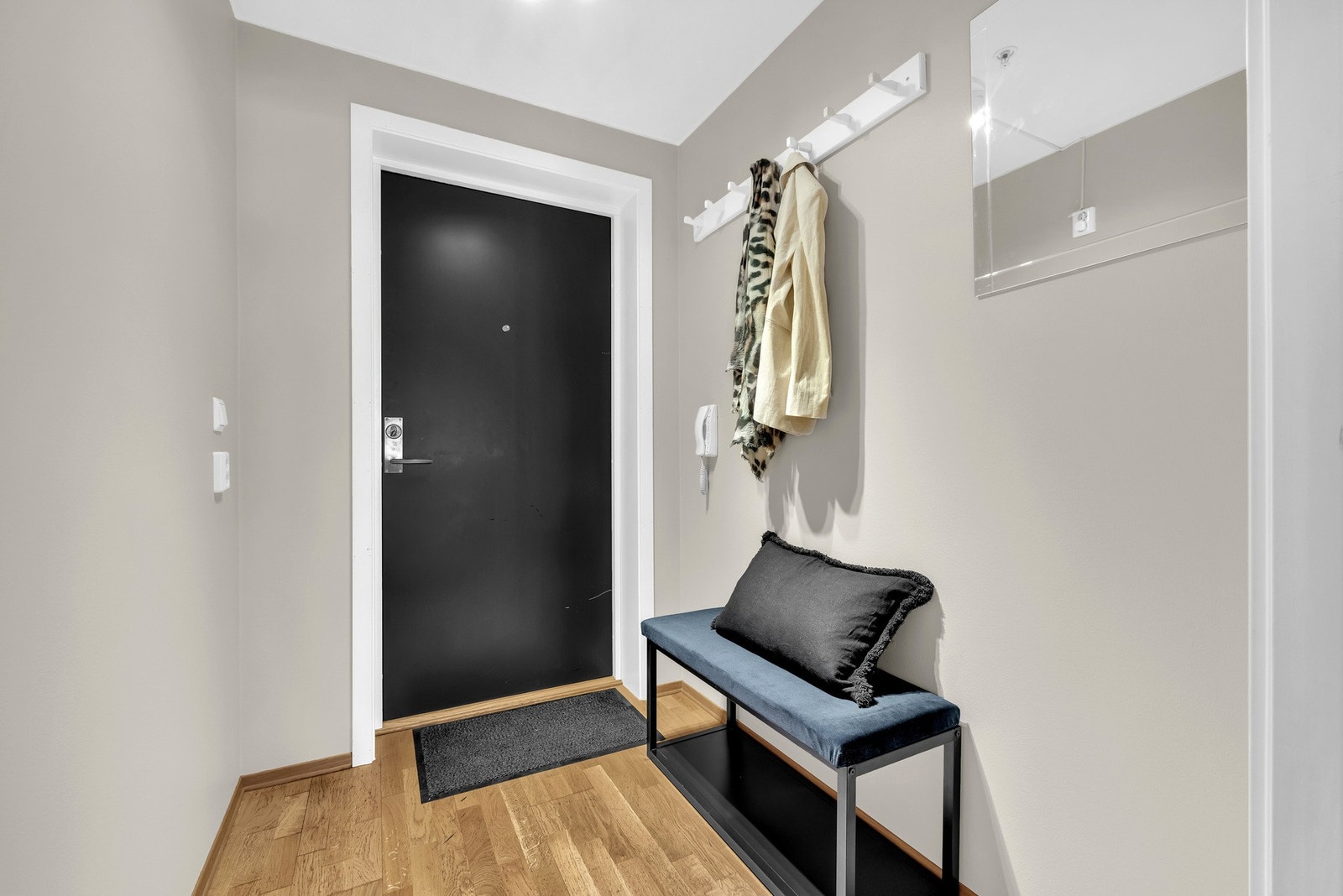 Velkommen inn i en lys entré, hvor du har plass til å henge fra deg yttertøy på vegghengt knaggrekke og skohylle. Entréen har lysmalte vegger, hvit himling og parkett på gulvet. Galleribilde