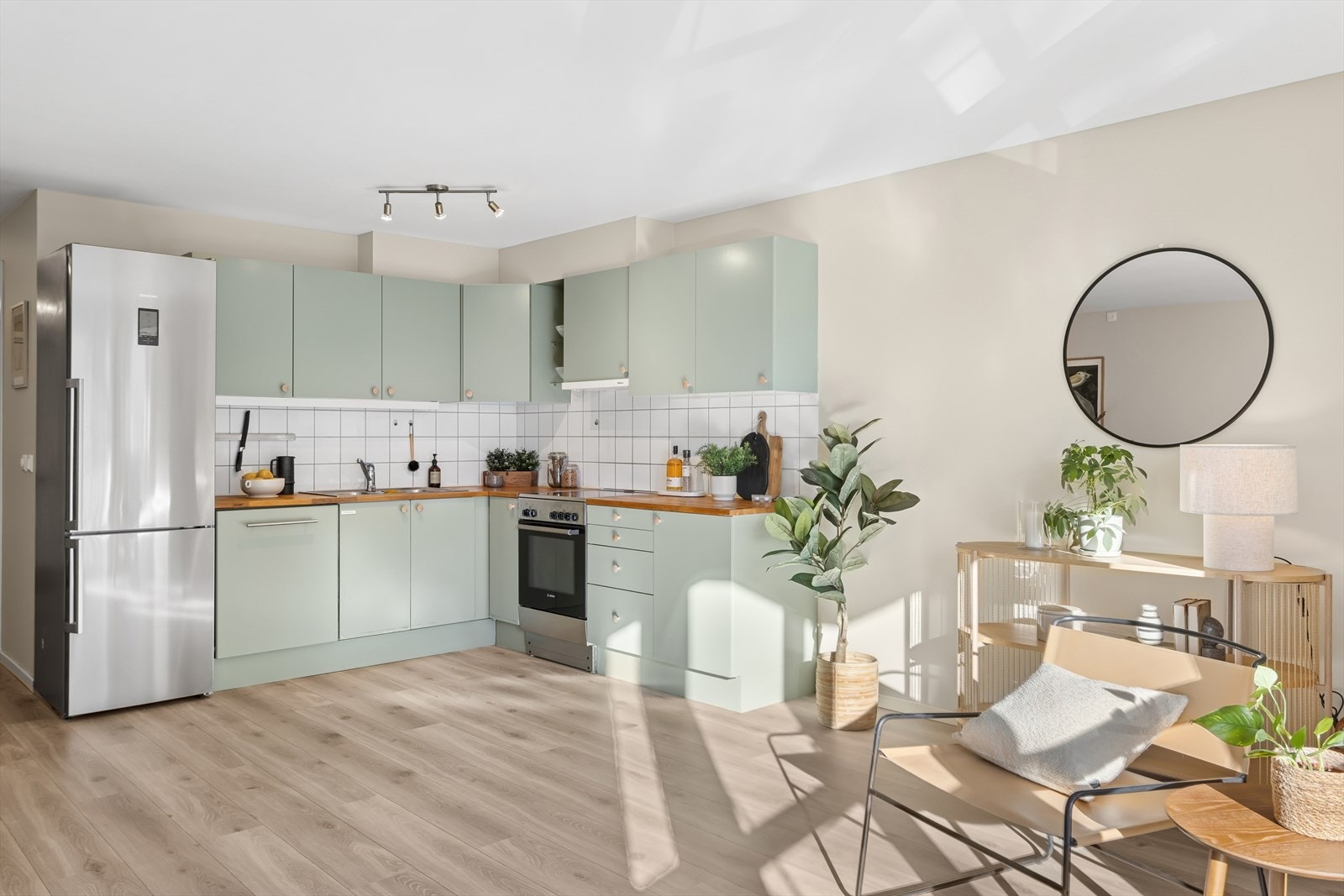 Kjøkkenet har en plan, malt innredning og en benkeplate i heltre. Kjøkkenfrontene ble malt i februar 2025, og håndtakene ble byttet. Galleribilde