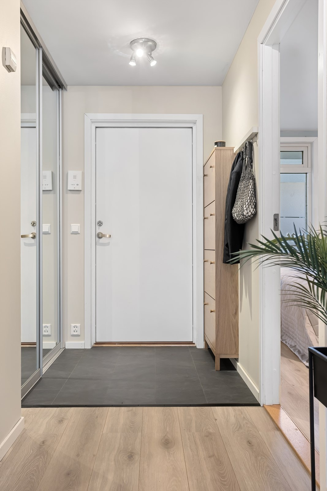 Entré med plass til å henge fra seg yttertøy og sette fra seg sko i en skyvedørsgarderobe med speilfronter. Galleribilde