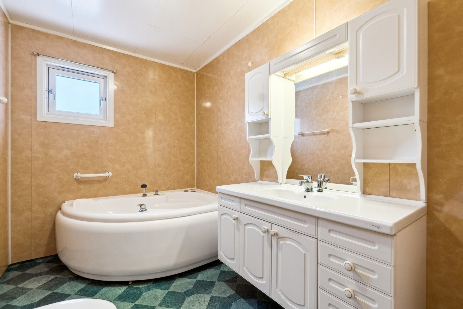 Boligen har 2 bad, en svært familievennlig og praktisk løsning. Det ene badet finner du ved gangen, og dette er boligens største bad med hjørnebadekar, servantskap og toalett. Galleribilde