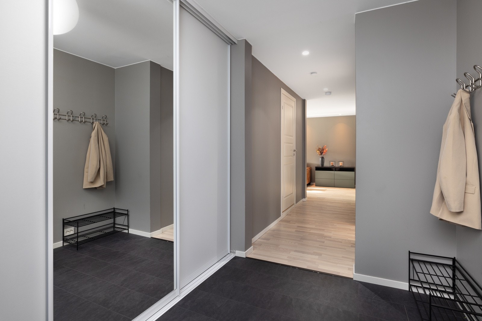 Entréen er romslig og lys, med en praktisk skyvedørsgarderobe og god plass til oppheng av yttertøy både i garderobe og annet møblement. Galleribilde