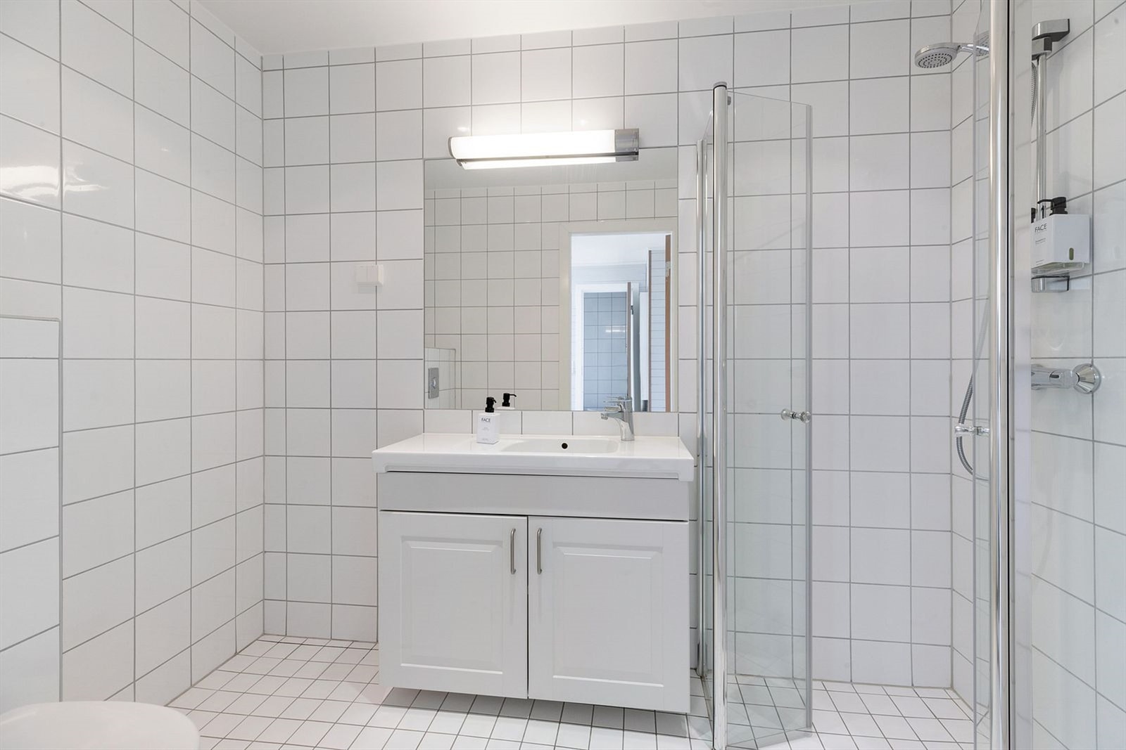 Flislagt baderom med toalett, servant og dusj Galleribilde