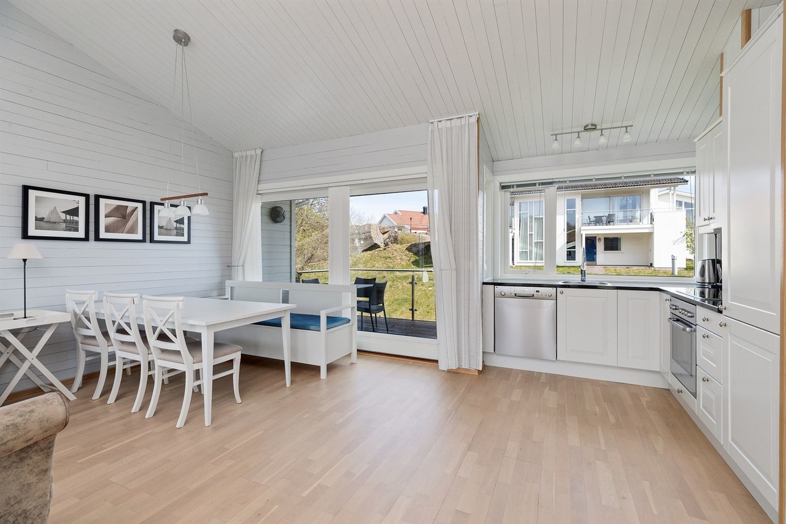 Kjøkkenet og stuen ligger i åpen løsning og det er utgang til veranda på begge sider Galleribilde