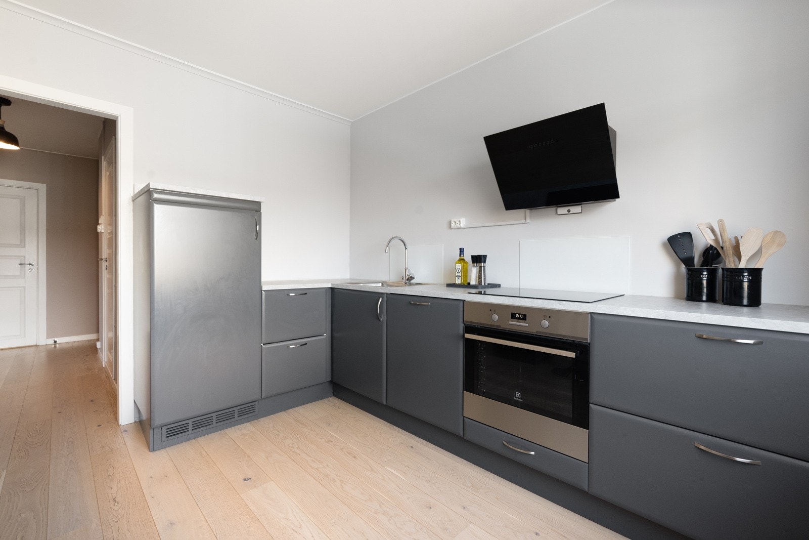 Kjøkkenet har innredning med laminerte skrog, glatte fronter og laminert benkeplate med kjøkkenkum. Godt med skap- og benkeplass. Galleribilde