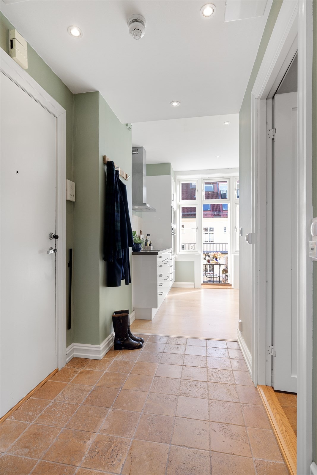 Velkommen inn i lys, flislagt entré med gulvvarme og plass til klesoppheng. Delvis åpen kjøkkenløsning mot entré. Galleribilde