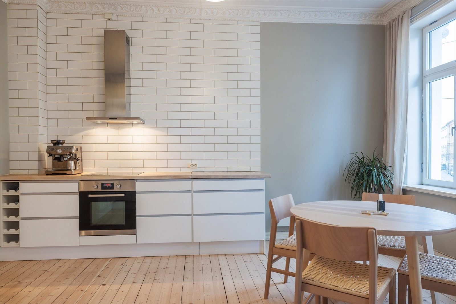 Kjøkkenet utstyrt med integrerte hvitevarer som oppvaskmaskin, stekeovn med induksjonstopp og kjøleskap med frysedel. Galleribilde