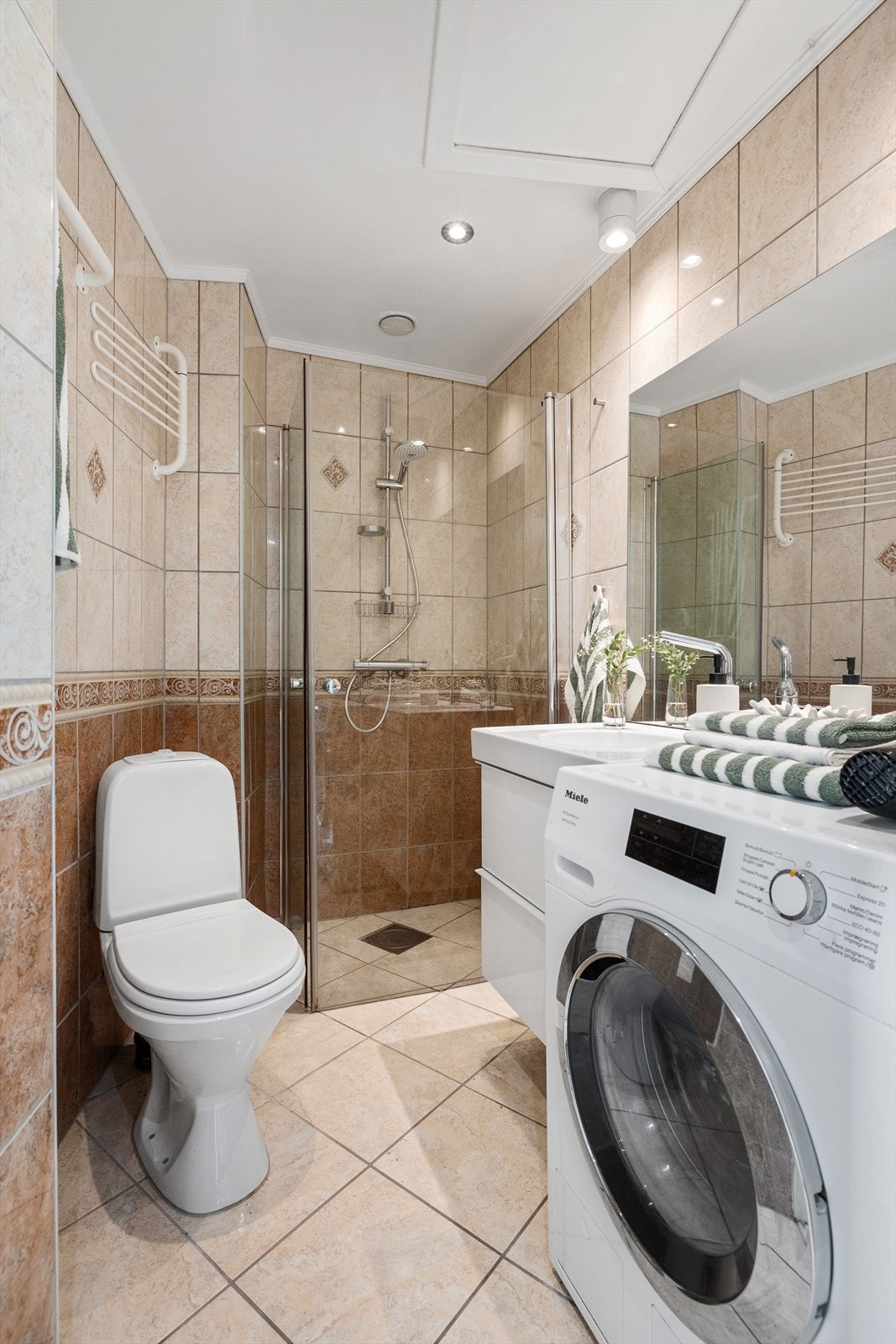 Flislagt bad med opplegg for vaskemaskin. Galleribilde