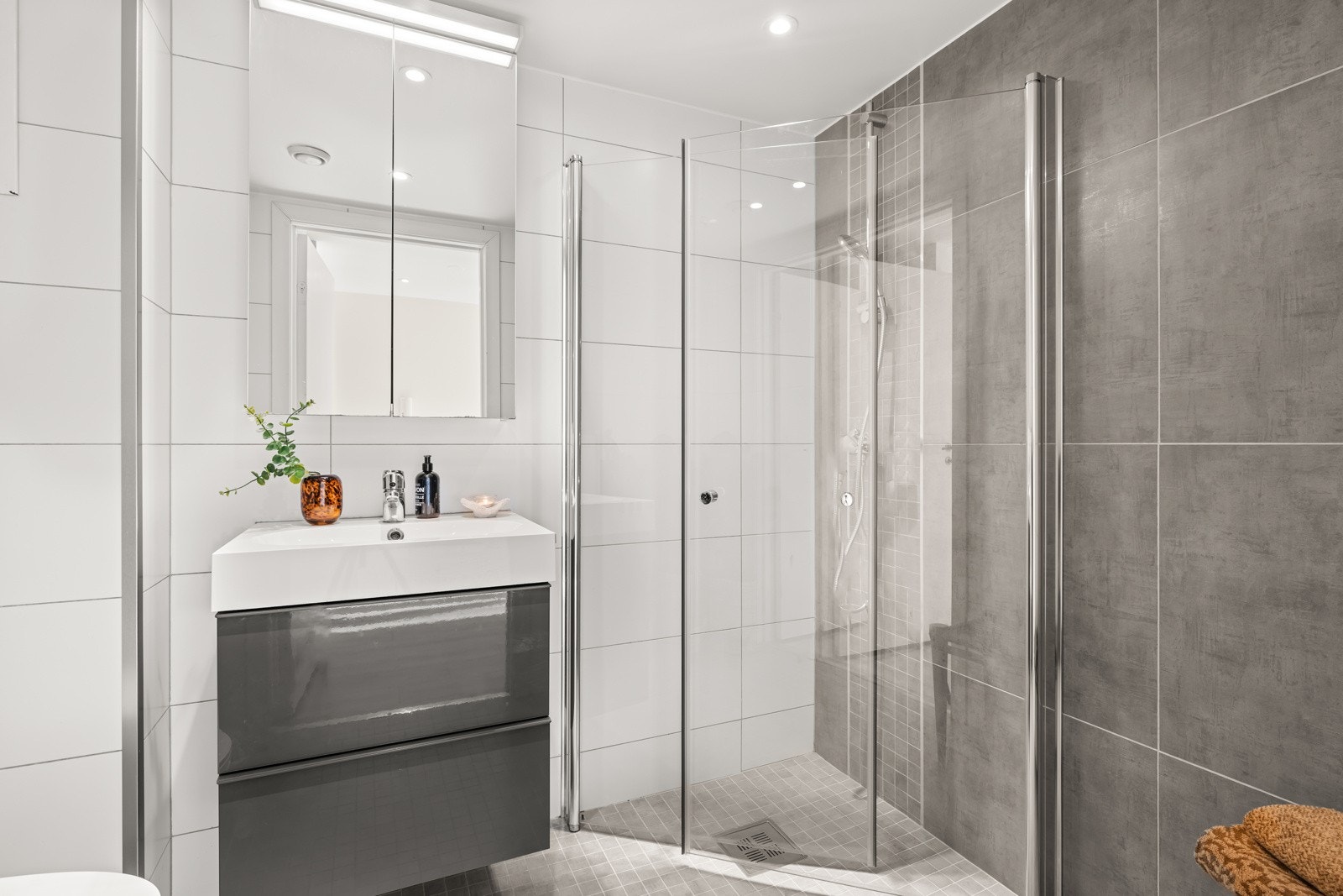 Baderommet er utstyrt med veggmonterte dusjvegger og en romslig dusjsone direkte på gulv, komplett med termostatbatteri for en behagelig dusjopplevelse. Galleribilde